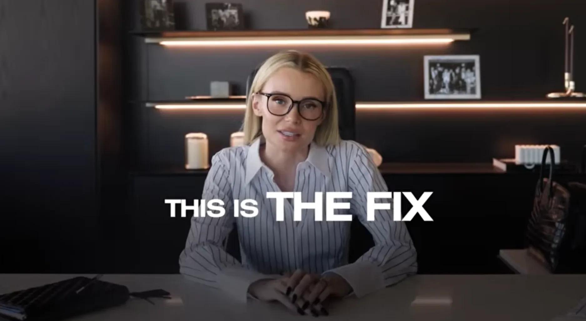 A businesswoman wearing glasses speaking to the camera in a modern office with the text “This Is The Fix”