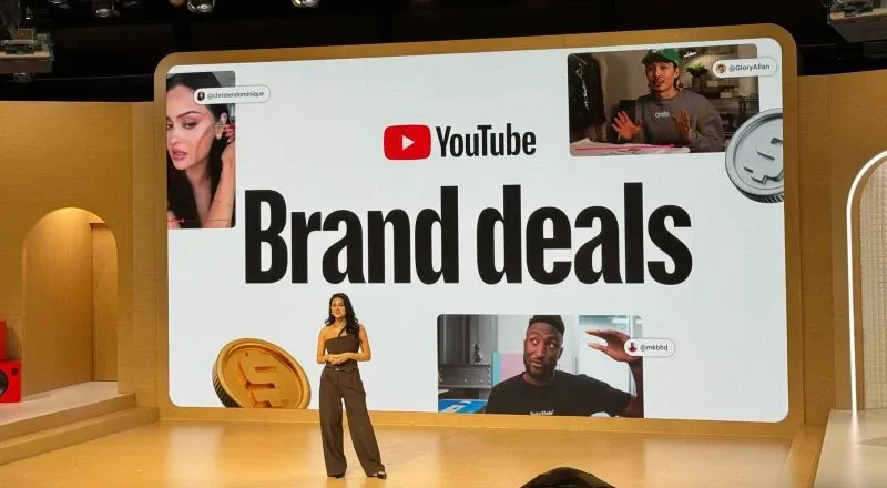 Presenter on stage showcasing YouTube Brand Deals on a large screen